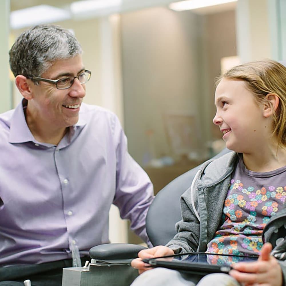 Dr. Helpard talks to a young patient about her oral health.